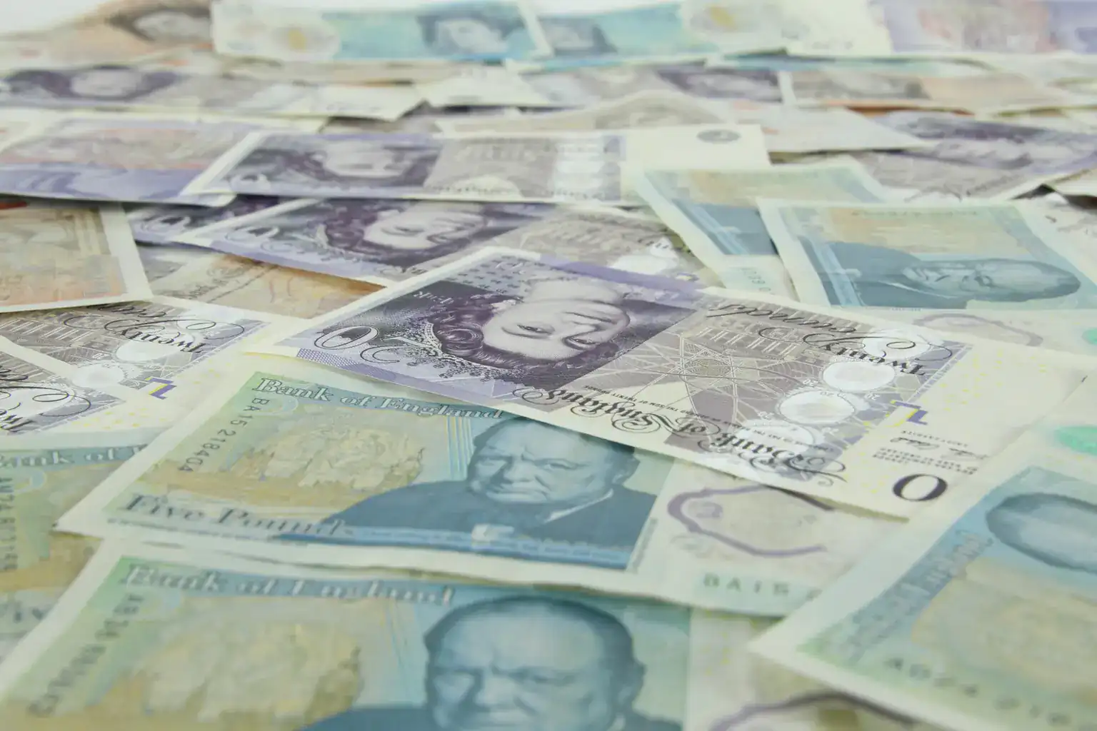 British five and twenty pound notes scattered across a table