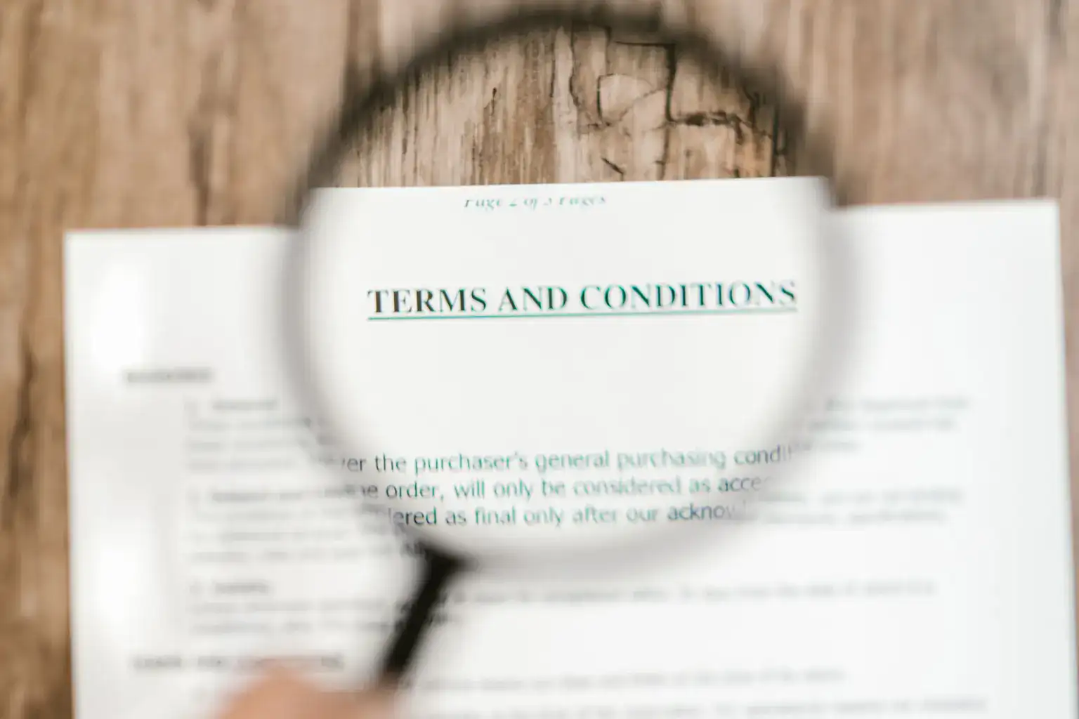A magnifying glass held over the Terms and Conditions heading of a printed document